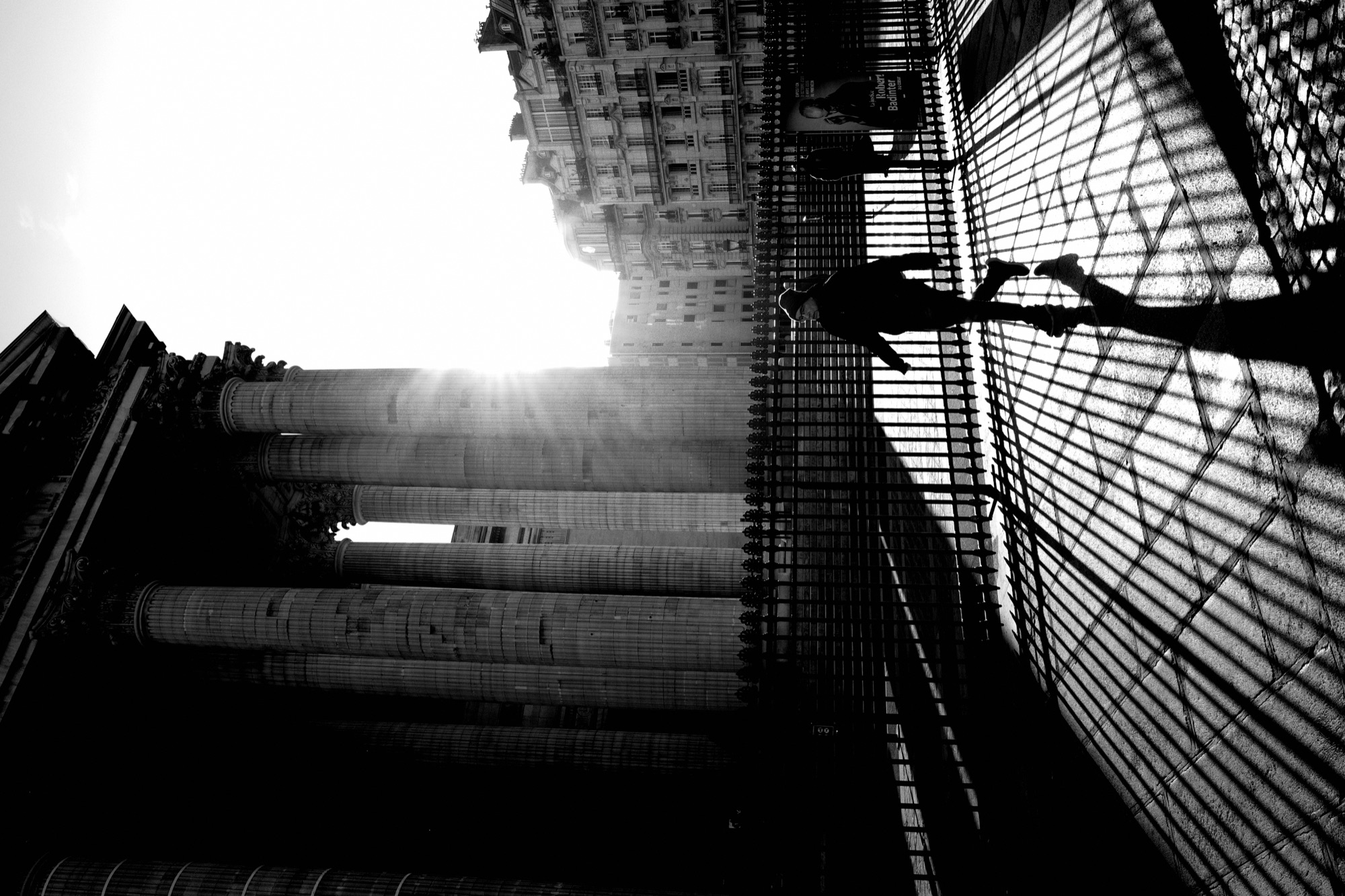 Looking up at grand columns with sun flare through glass structure