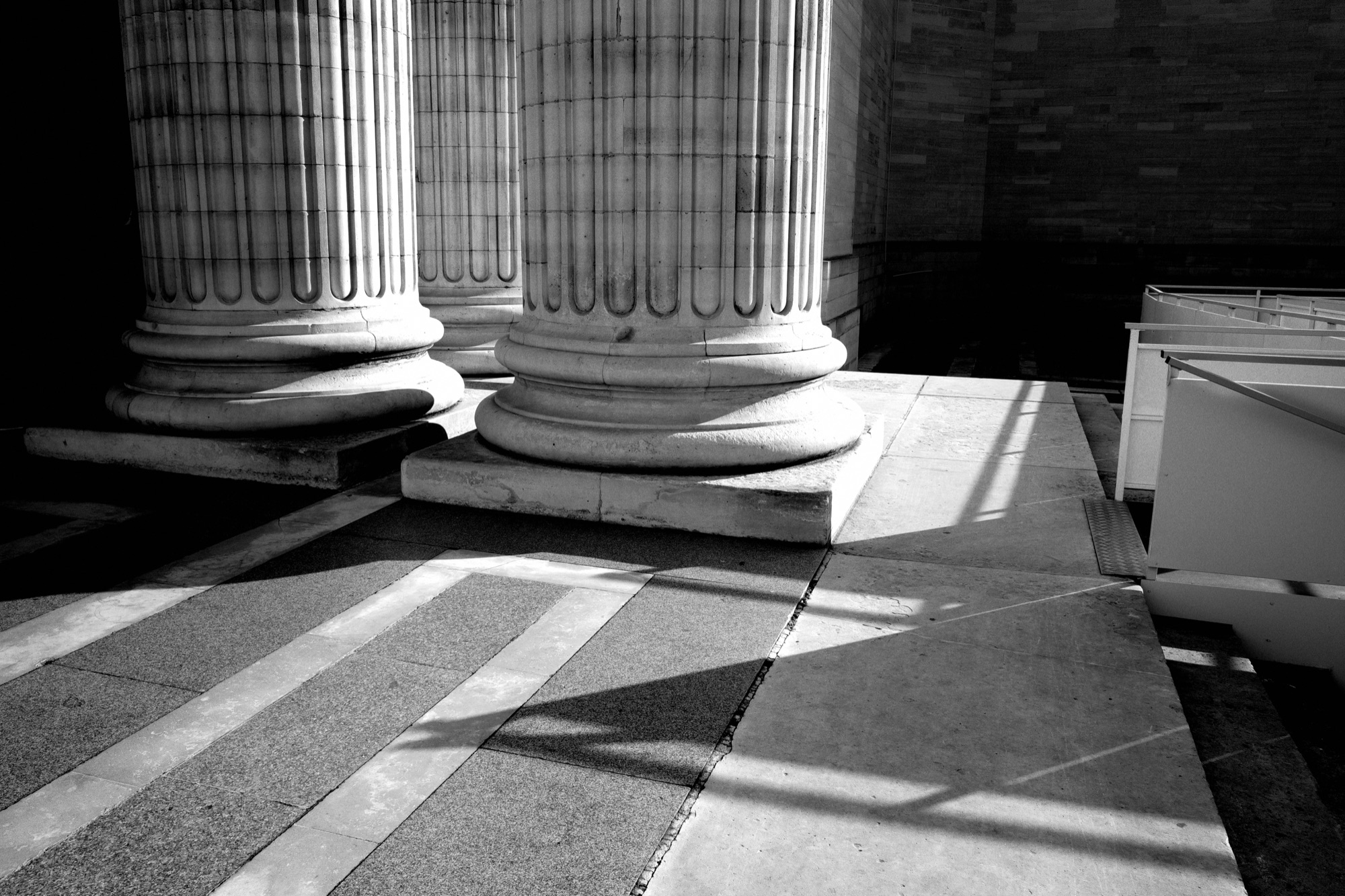 Classical columns casting striped shadows across a stone floor