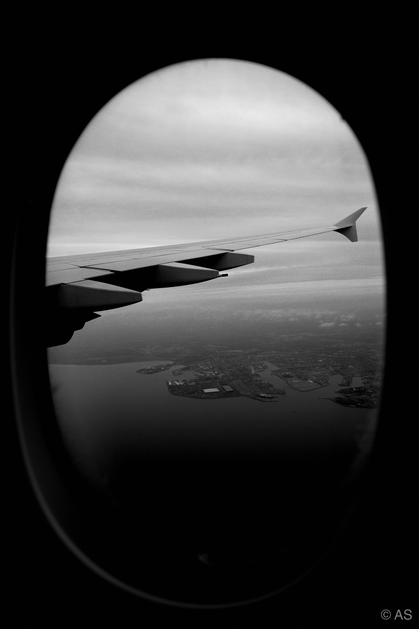 View through an airplane window over coastline and ocean