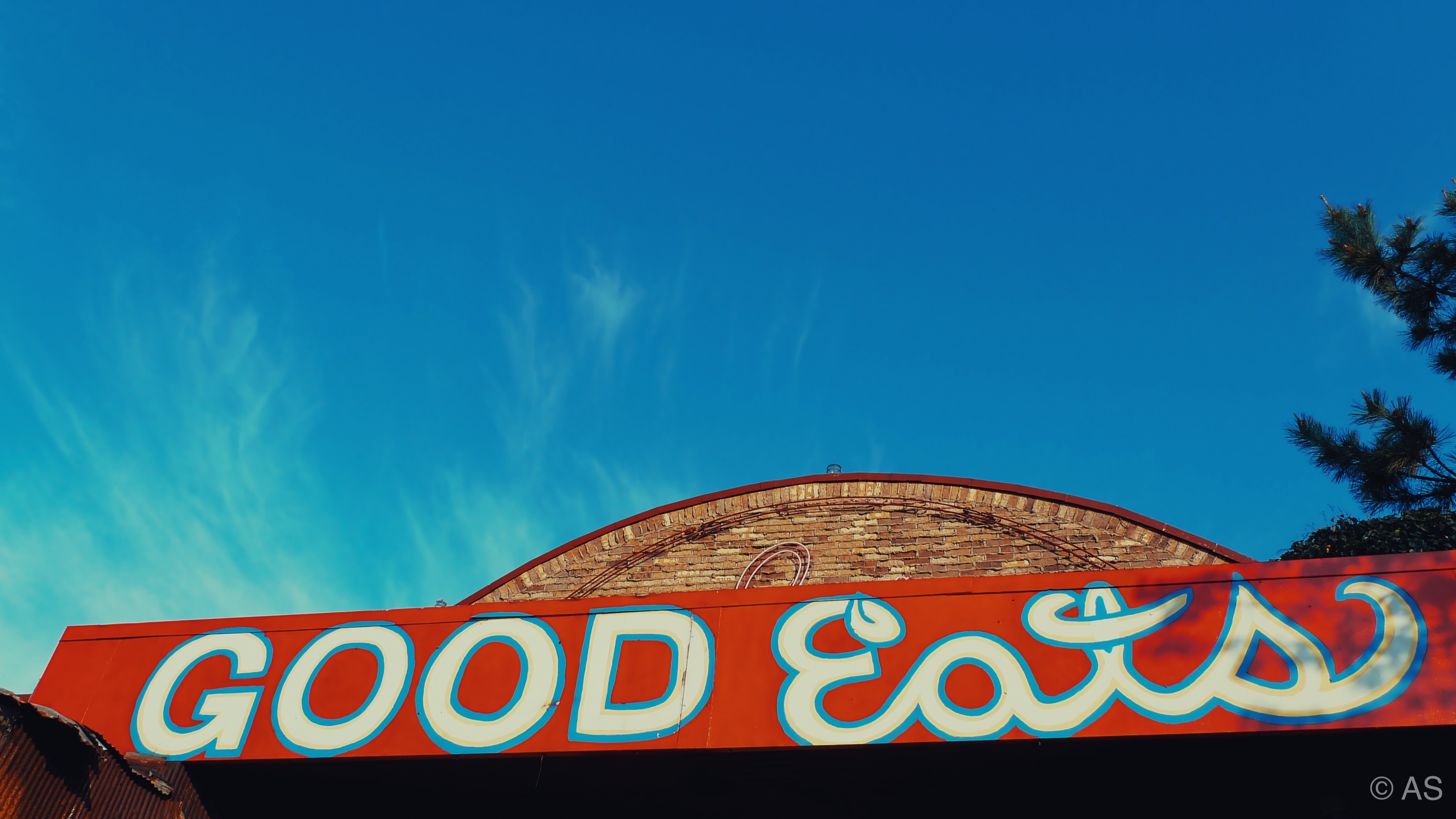 Good Eats diner sign in bold red against a vivid blue sky